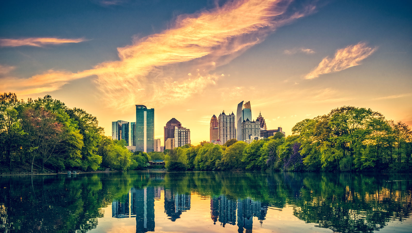 midtown atlanta surrounded by trees and a lake