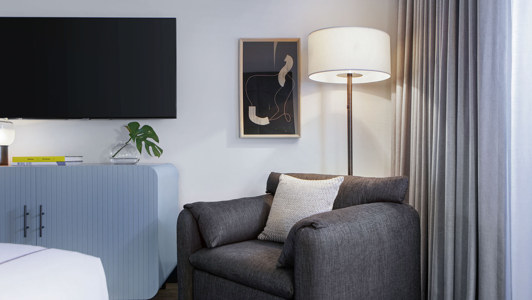 Kimpton Shane guestroom with large white king size bed and blue headboard