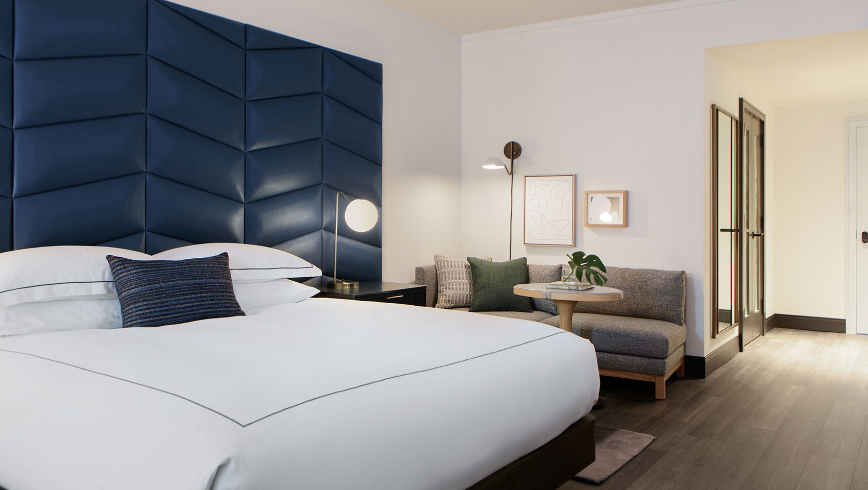 Kimpton Shane guestroom with large white king size bed and blue headboard