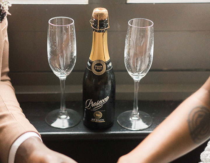 couple holding hands with champagne